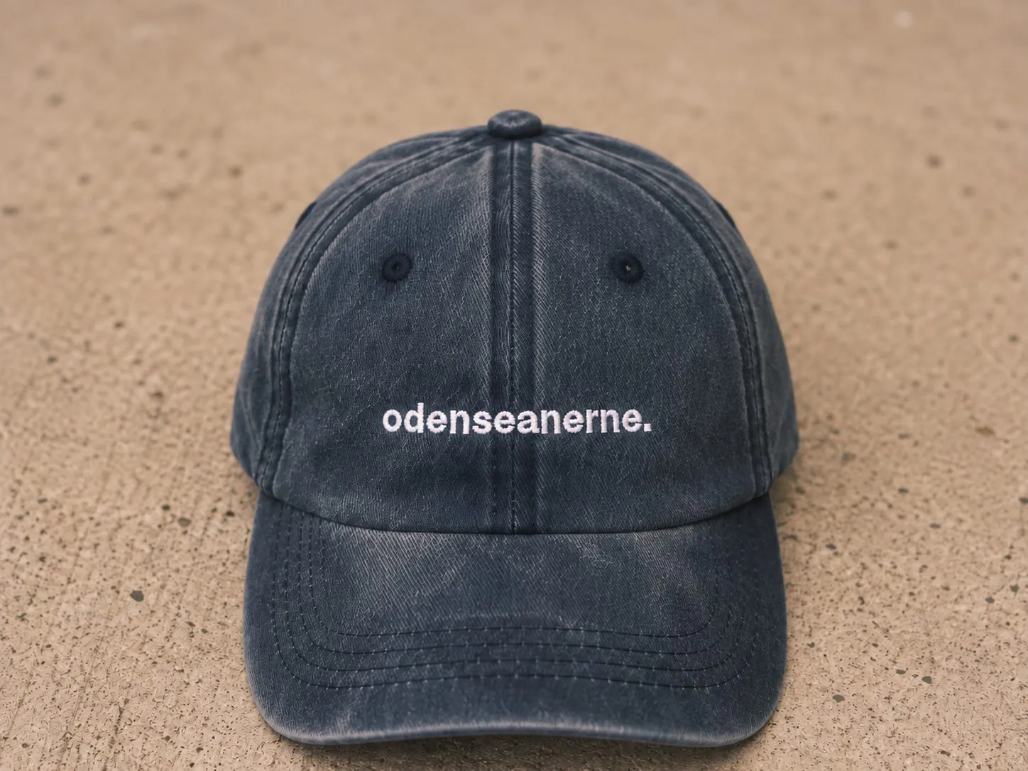 Blågrå kasket til børn med hvidt broderet odenseanerne.-logo